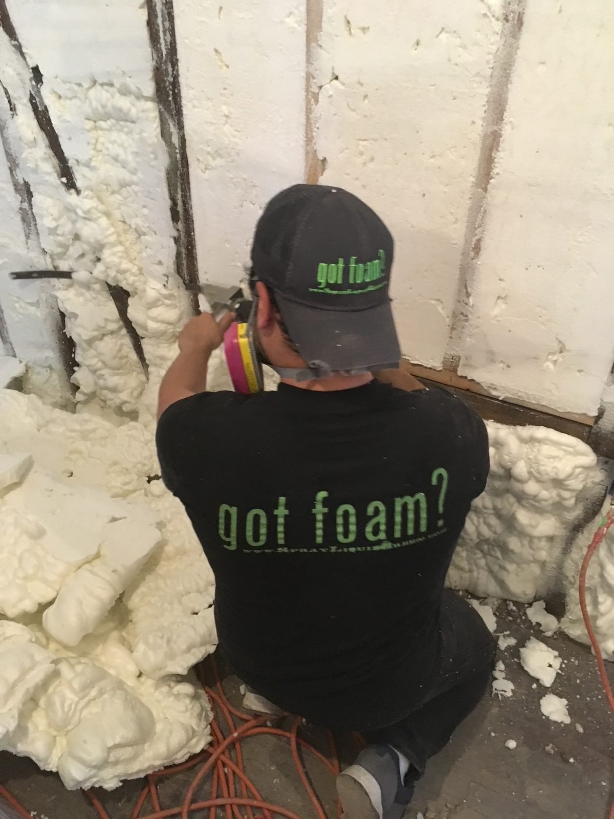 A two-person spray foam crew working together on a residential job — a real-world example of industry-standard work ethic and team coordination.